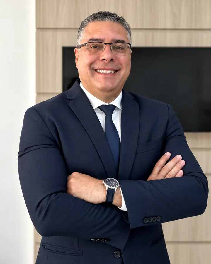 Dr. Rubem Ribeiro Neto, advogado, de terno escuro e braços cruzados no escritório em Belo Horizonte